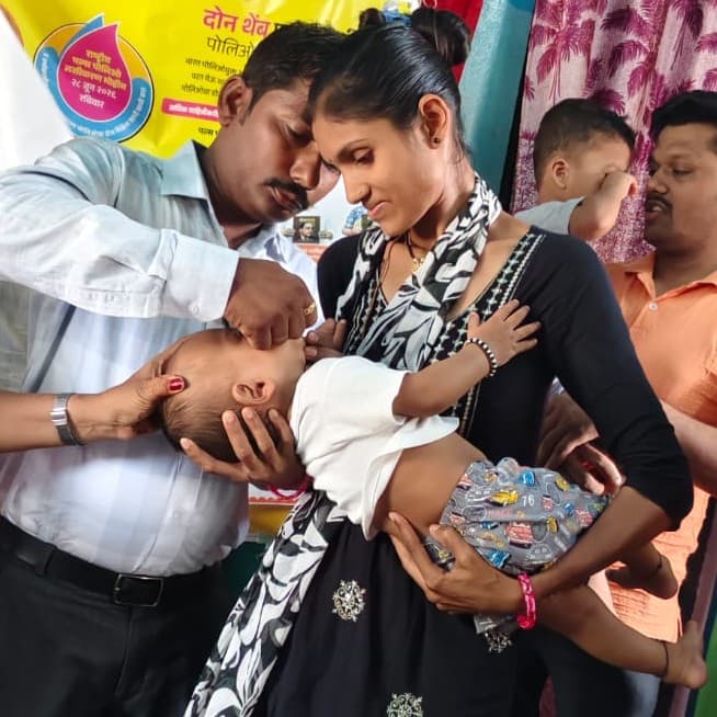 Pulse Polio Abhiyan — administering polio drops to an infant